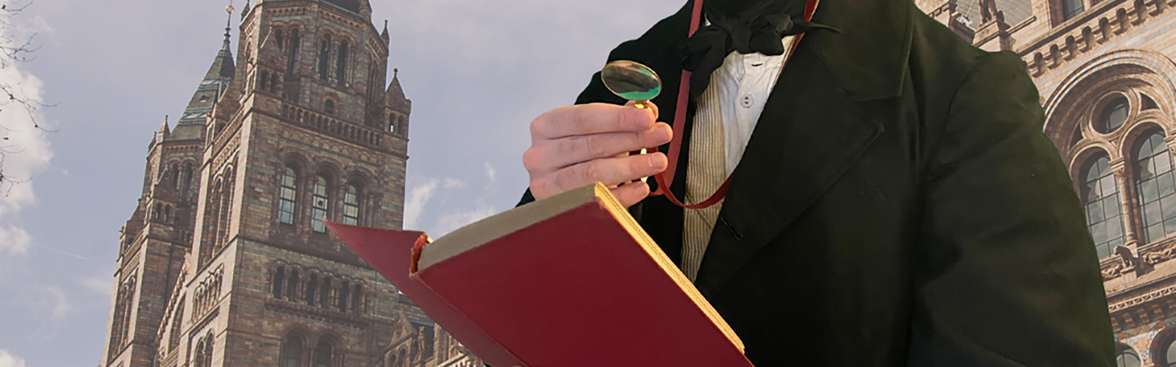 A man holds a magnifying glass with one hand and holds an open book with the other as the Waterhouse building is pictured on the background