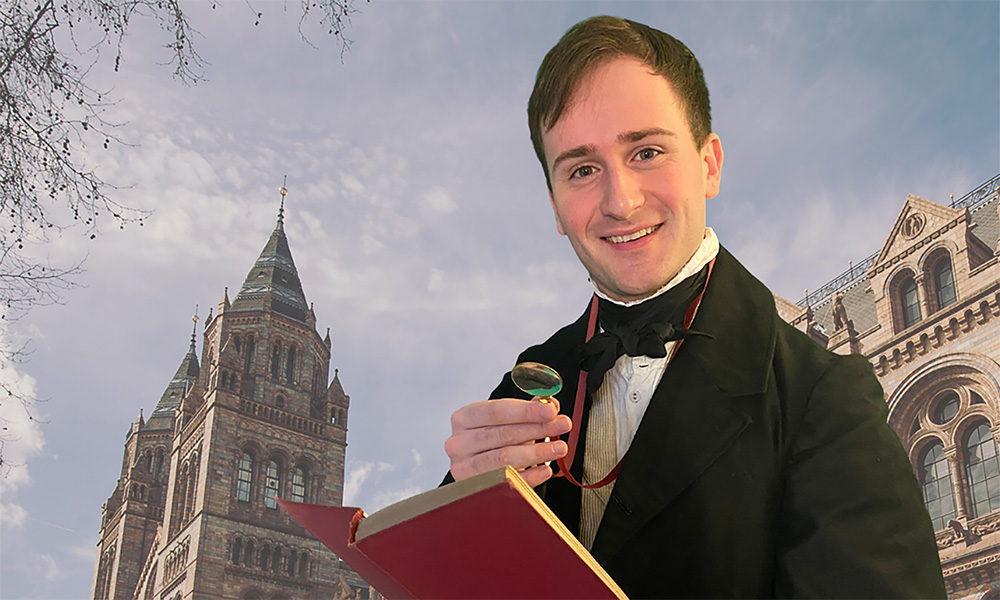 A man holds a magnifying glass with one hand and holds an open book with the other as the Waterhouse building is pictured on the background