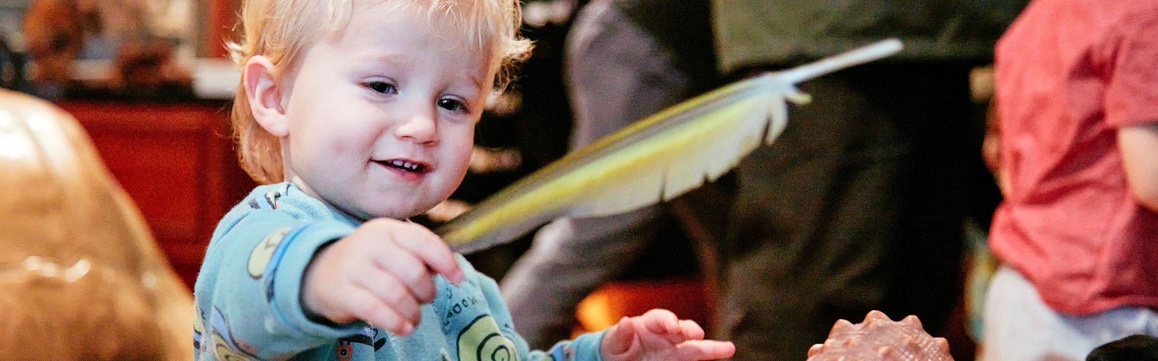 A child plays with a feather