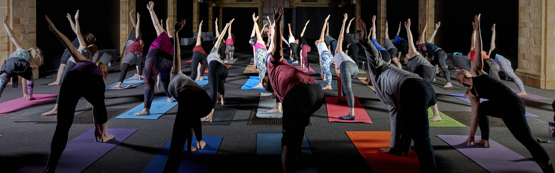 Group of people stretch on yoga mats at Hintze Hall