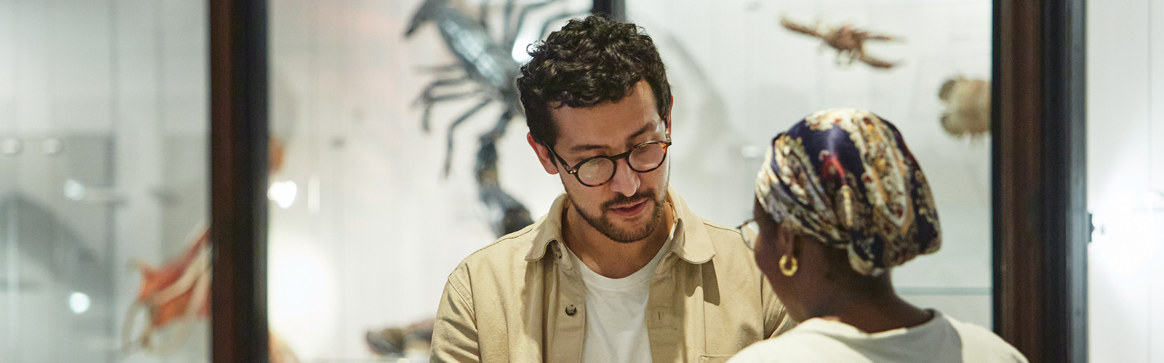 Two people looking at a sheet of paper talk 