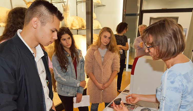 Sixth form students at Tring discussing a specimen with a scientist 