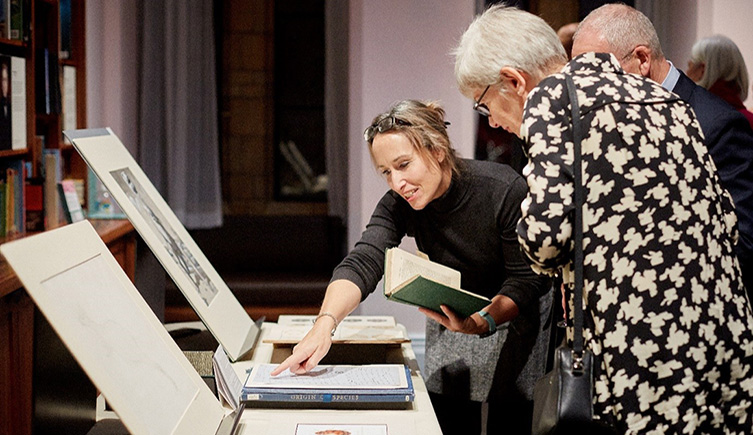 People looking at rare books and pointing 