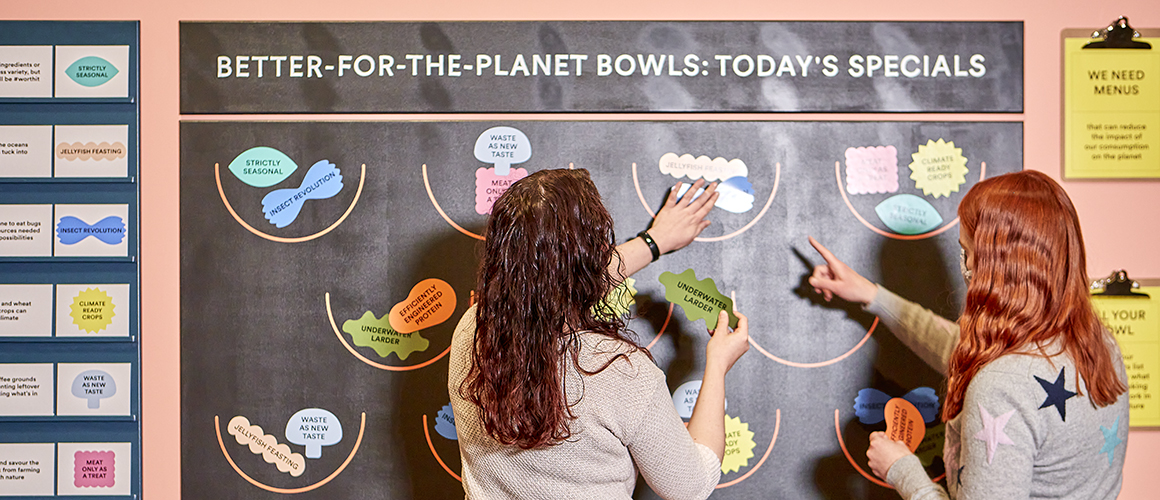 Visitors enjoying an interactive display as part of the Our Broken Planet exhibition