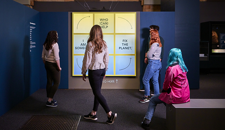 Visitors enjoying an interactive display as part of the Our Broken Planet exhibition