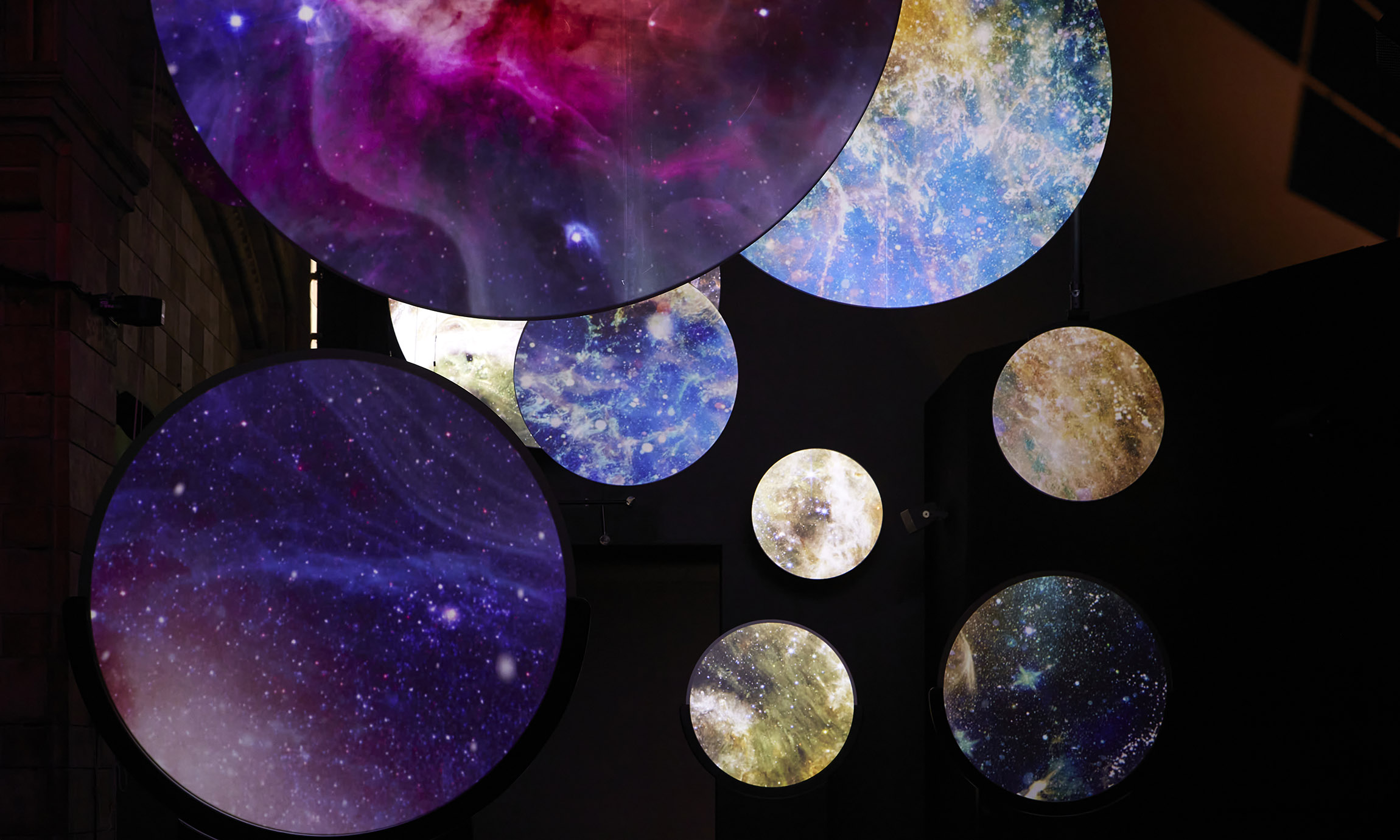 Planets and stars on different sizes are seen over a black background