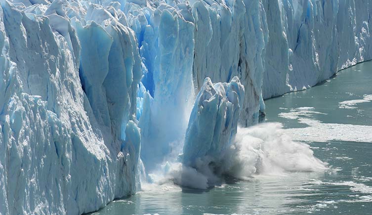A chunk of ice falls from a glacier.