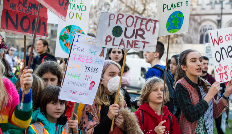 Young climate protestors demonstrate with placards in London