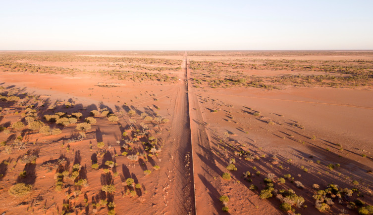 The dingo fence stretching through the dusty Australian countryside.