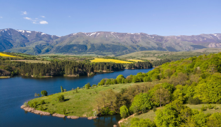 A river winds through countryside below the Sredna Gora mountains