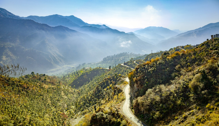 Mist rises above the mountains surrounding the Shimla Valley