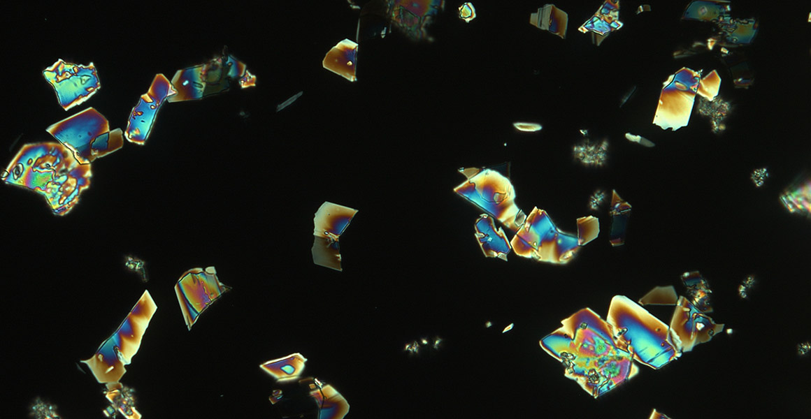 Multicoloured lithium crystals on a black background. 