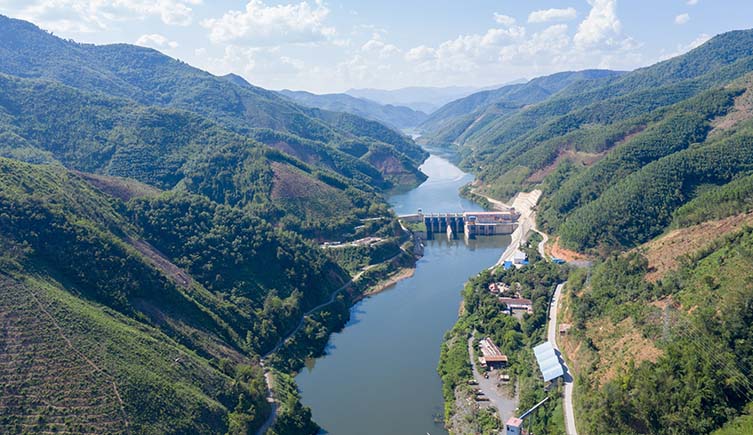 A dam stretches across the Mekong river between two steep banks.
