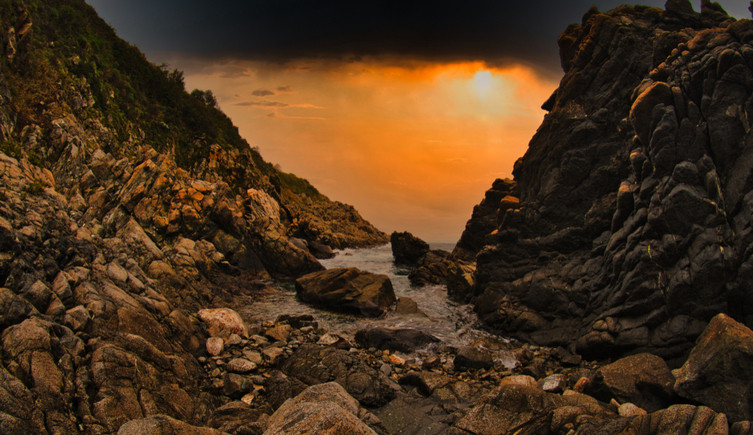 The bay of Rovaglioso with sunlight streaming through the clouds