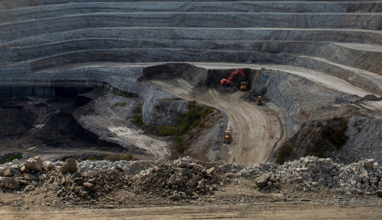 Trucks wind their way through a dusty coal mine.
