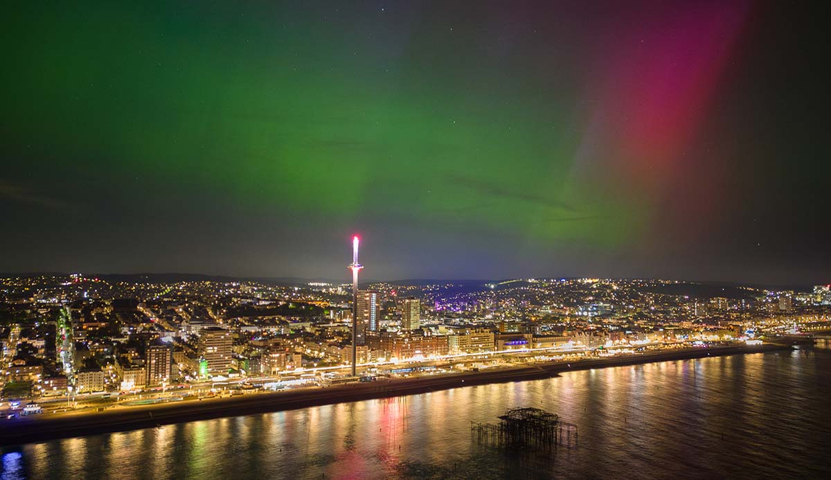 A green and red aurora hangs over Brighton’s seafront.