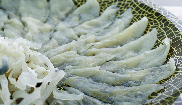 A plate of pufferfish sashimi arranged in a flower-like shape