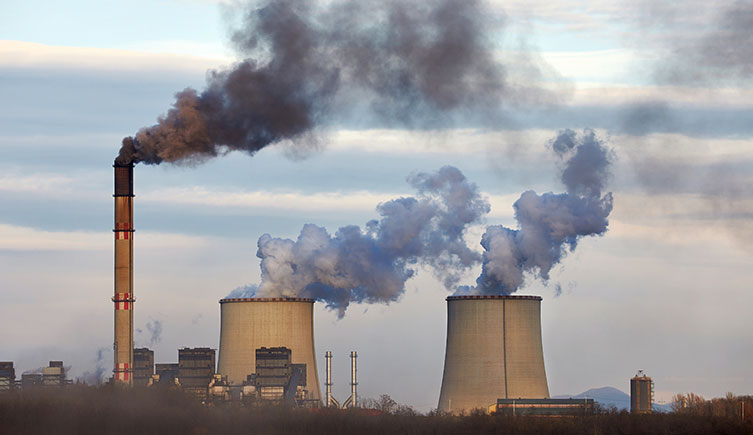 Smoke and steam pouring out of power plant chimneys