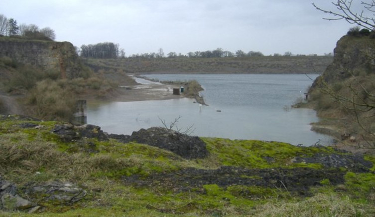 A photograph of Cromhall quarry, filled with water