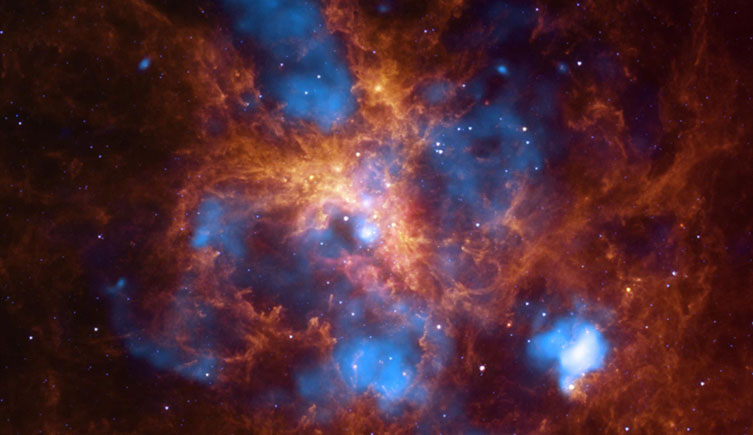 Bubbles of superheated gas (blue) break up cooler gas and dust (red). The sky is also filled with hundreds of stars. 