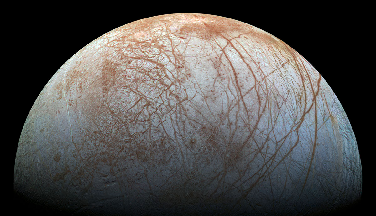 A large white, spherical moon, with its surface partly covered in irregular brown lines and markings 