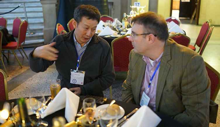 Paul Barrett and Xu Xing sat at a table talking to each other.  
