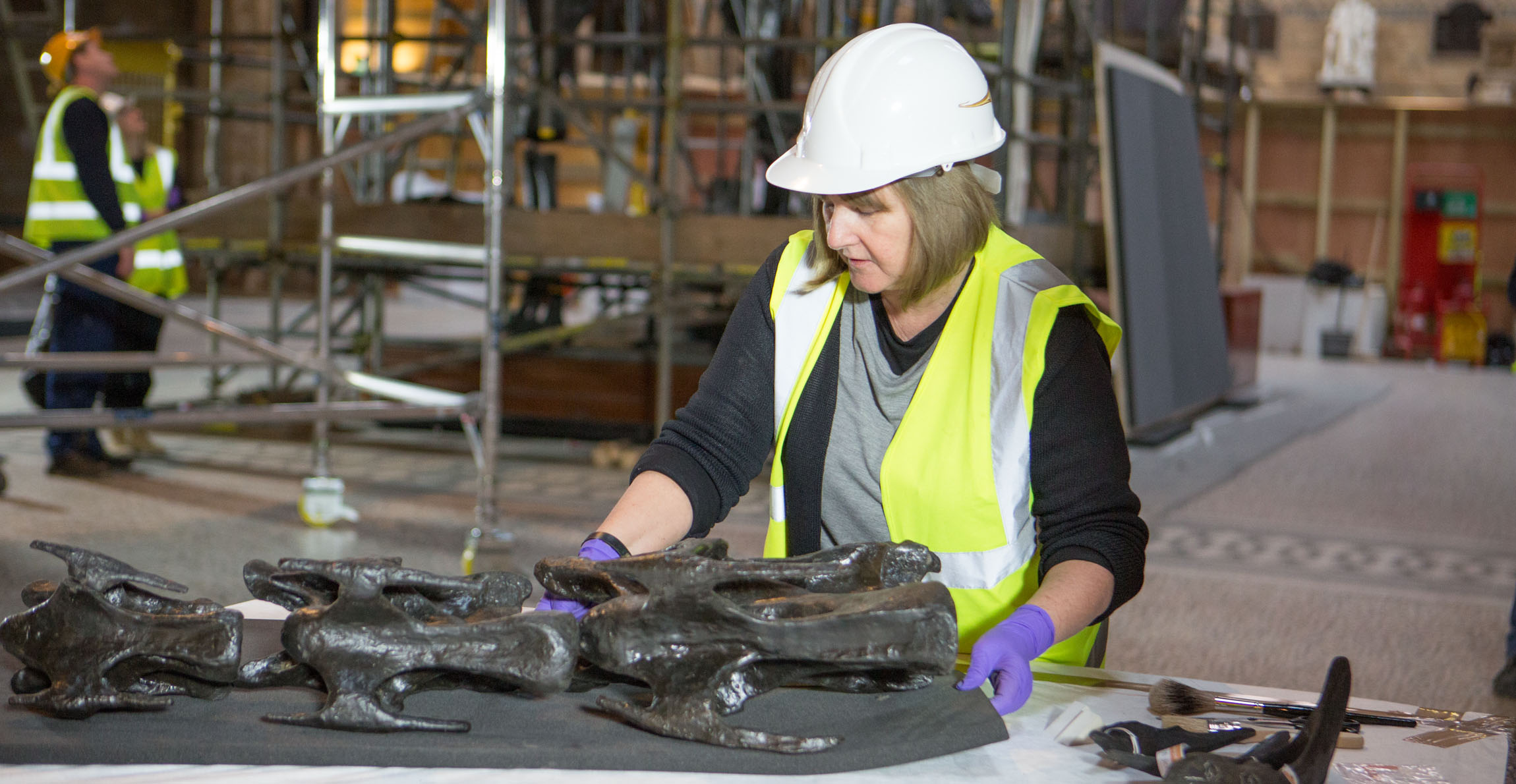 Lorraine in the main hall of the Natural History Museum looks over some of the vertebrae of a dismantled Dippy
