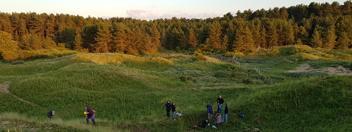 People in a field with trees behind them