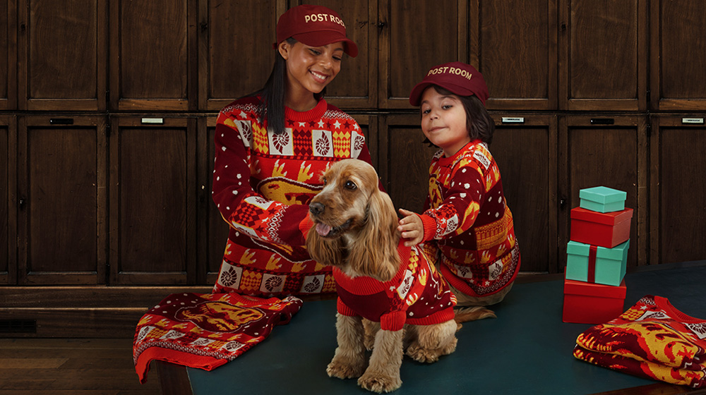 A woman and young child dressed in our Christmas jumper stroke a cocker spaniel who is also dressed in a matching Christmas jumper for dogs.