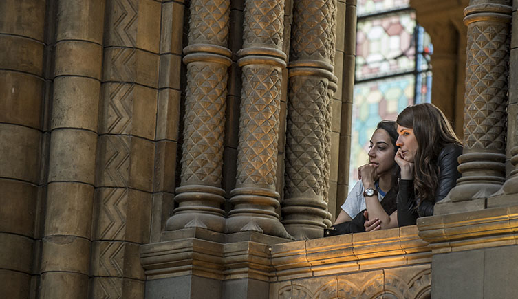 Two visitors enjoying an evening event in Hintze Hall