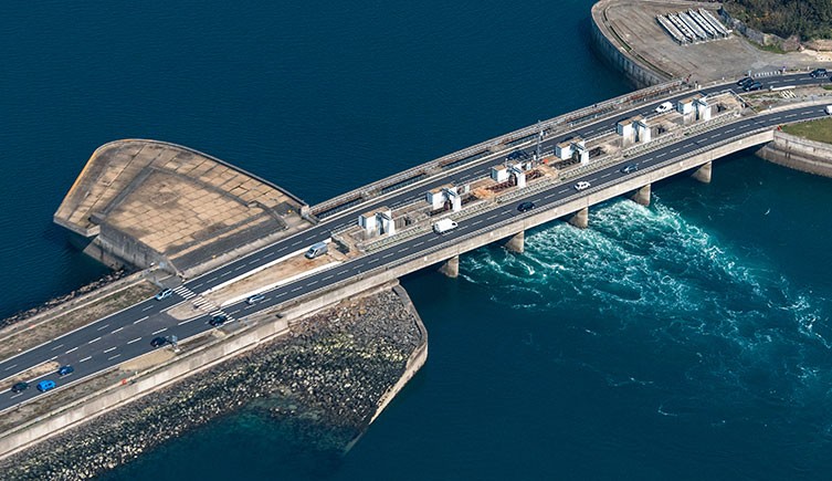 Aerial view of a tidal power plant that has been integrated with a bridge