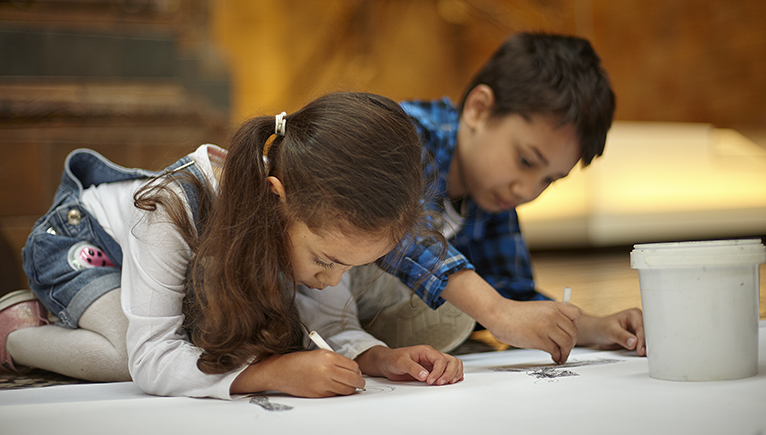 Two children drawing in the museum