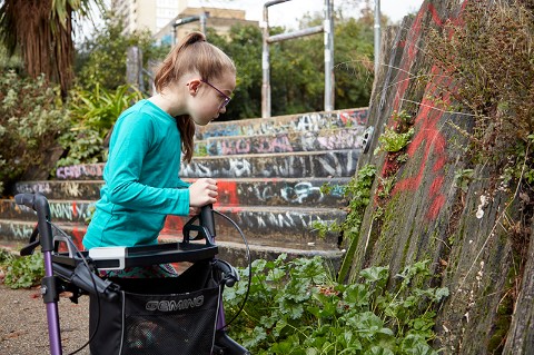 A girl looks at moss on a wall
