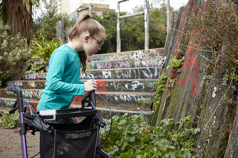 A girl looks at moss on a wall