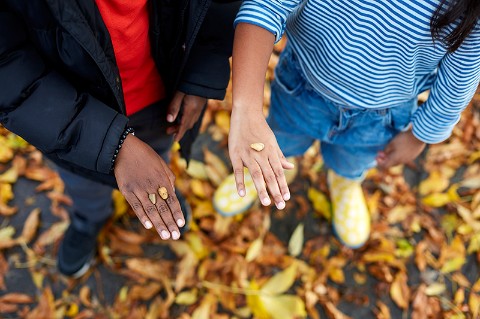 Two children hold stones on the backs of their hands